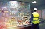 Worker using legacy OT systems in a factory control room